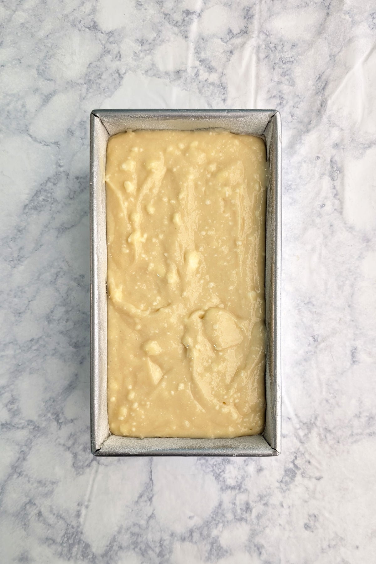 Batter for ricotta pound cake, in a greased and floured loaf pan, before baking.