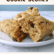 Two chocolate chip cookie scones topped with brown sugar, on a plate, with one torn open to show texture. Text overlay reads "Chocolate Chip Cookie Scones. Freeze Unbaked. Chewy, Chocolatey, Ready When You Are."