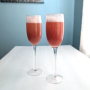 Two strawberry bellinis in champagne flutes.