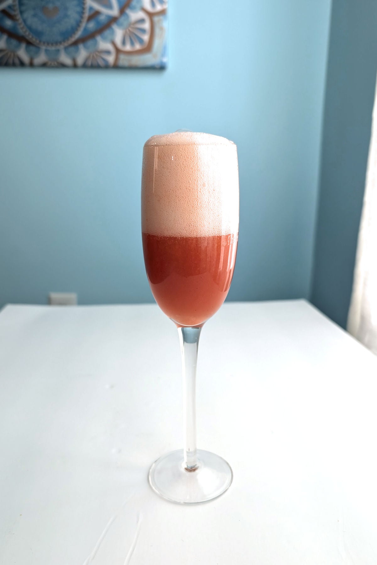 Strawberry bellini in a champagne flute, topped off with prosecco.