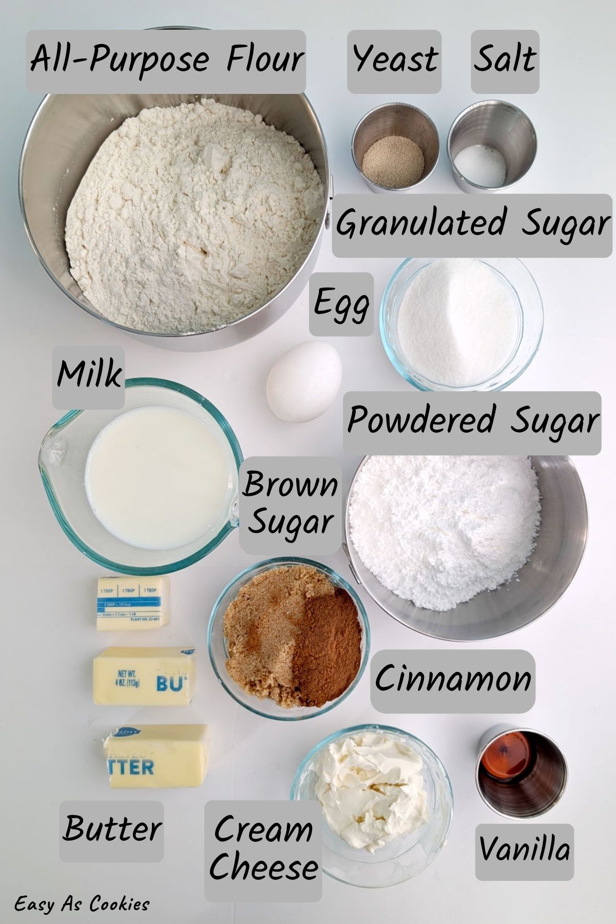 Ingredients for overnight cinnamon rolls, including flour, yeast, salt, granulated sugar, milk, butter, brown sugar, cinnamon, egg, powdered sugar, cream cheese, and vanilla.