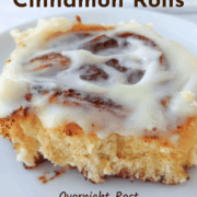 A cinnamon roll with cream cheese icing, on a plate. Text overlay reads "Overnight Cinnamon Rolls. Overnight Rest. Cream Cheese Frosting."