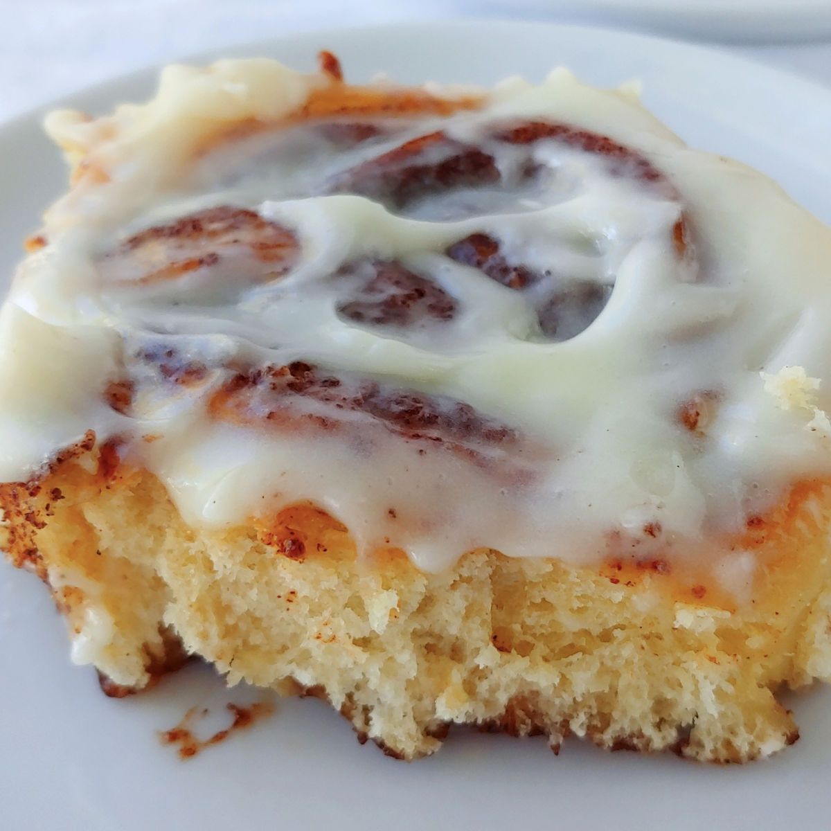 A cinnamon roll with cream cheese glaze.