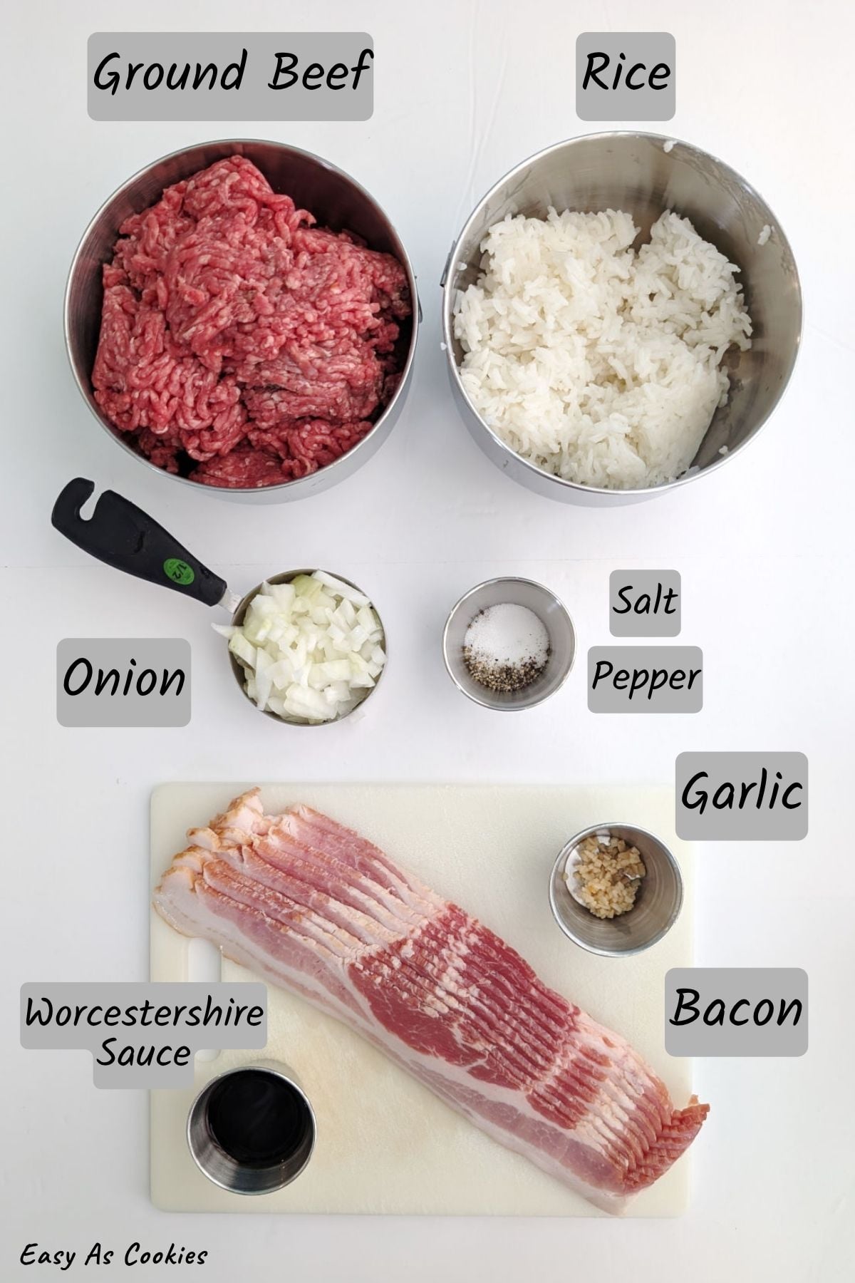 Ingredients for fake steak or mock filet mignon, including ground beef, cooked rice, chopped onion, salt, pepper, minced garlic, Worcestershire sauce, and bacon.