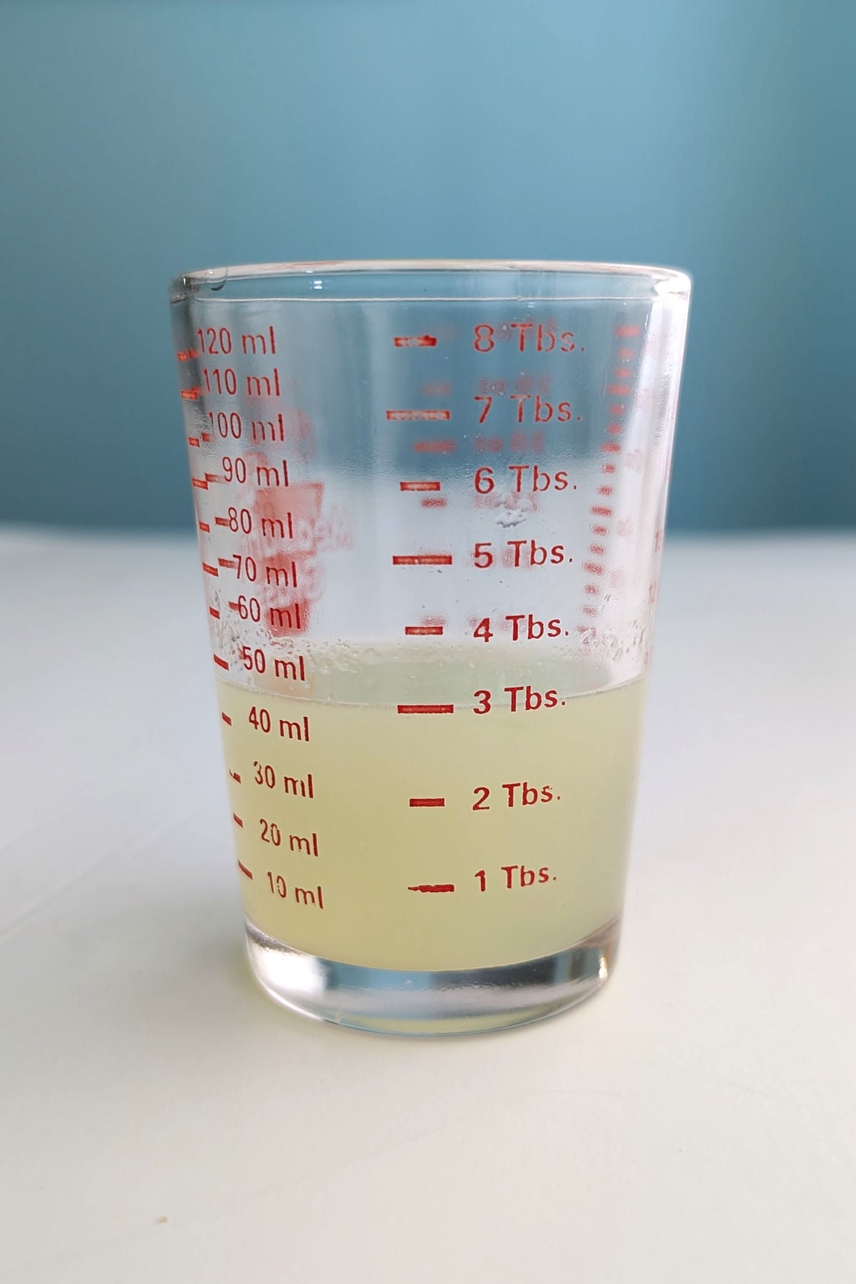 Lime juice in a small measuring cup.