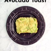 A slice of avocado toast on a plate. Text overlay reads "Basic Avocado Toast. Quick Healthy Breakfast. Easy As Cookies."