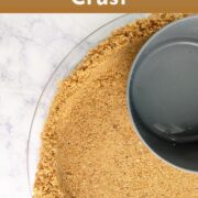 A measuring cup presses crumbs into a graham cracker crust in a pie plate. Text overlay reads "Graham Cracker Crust. Toasted for Extra Flavor. Easy As Cookies."