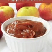 Apple butter in a white ramekin in front of apples. Text overlay reads "Slow Cooker Apple Butter. Warm and Appley. Easy As Cookies."