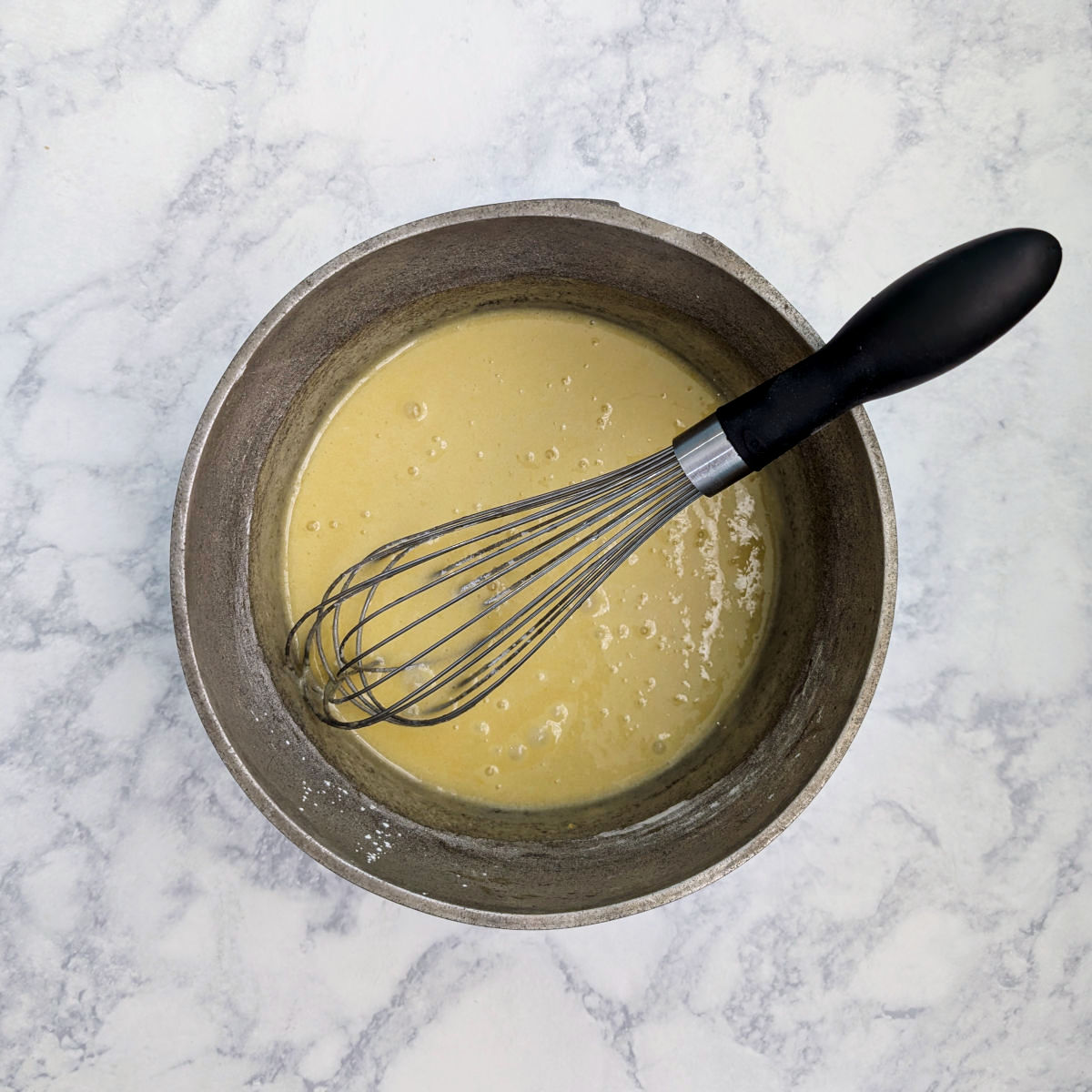Sugar, cornstarch, and whole eggs, whisked together in a saucepan, with wire whisk in it.
