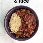 A bowl with slow cooker vegan red beans alongside cooked brown rice. Text overlay reads "Vegan Red Beans & Rice. No Sausage Needed. Easy As Cookies."