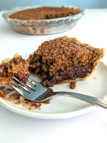 Bite of black bottom oatmeal pie on a fork, showing chocolate ganache topped with a chewy oat layer.