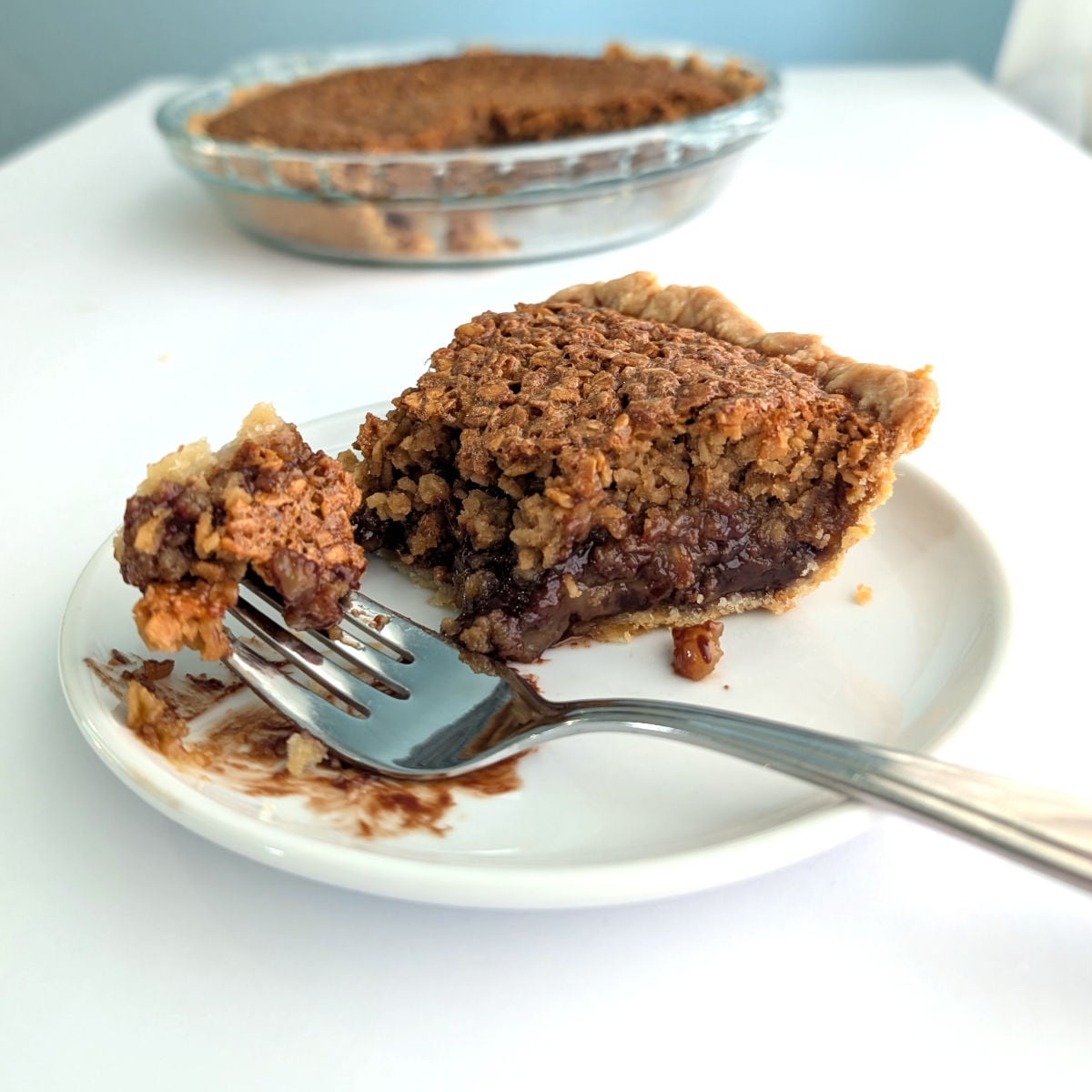 Bite of black bottom oatmeal pie on a fork, showing chocolate ganache topped with a chewy oat layer.